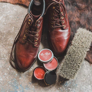 Burgundy Leather Cream and Shoe Polish Paste/Wax open with a pair of burgundy leather boots and a horsehair brush