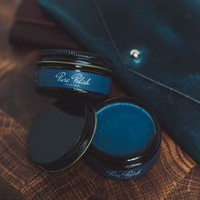 Load image into Gallery viewer, Open jar of Navy Blue Leather Cream Polish next to a navy blue leather wallet