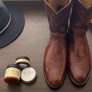 Pure Patina Shoe Polish and Leather Care Bundle used on these Justin Cowboy Boots on a table