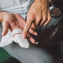 Load image into Gallery viewer, Man shows how a white premium shoe polishing cloth is supposed to be wrapped around the fingertips