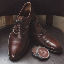 Load image into Gallery viewer, Pair of brown leather oxford shoes polished, next to an open tin of brown Pure Polish