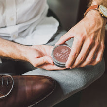 Load image into Gallery viewer, Man opens a tin of brown Pure Polish wax to polish a brown leather shoe on his lap